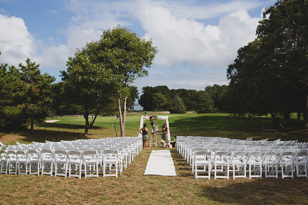 A documentary photograph of women decorating the ceremony site for a Martha's Vineyard wedding
