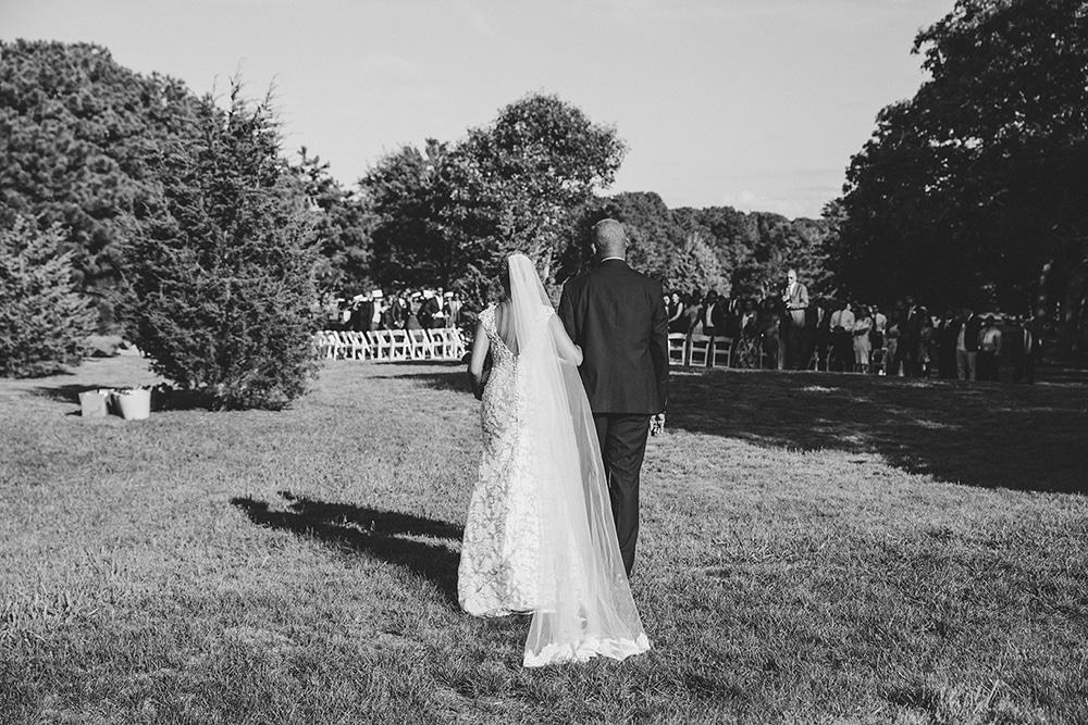 A documentary photograph of bride walking down the aisle with her father during her Martha's Vineyard Wedding