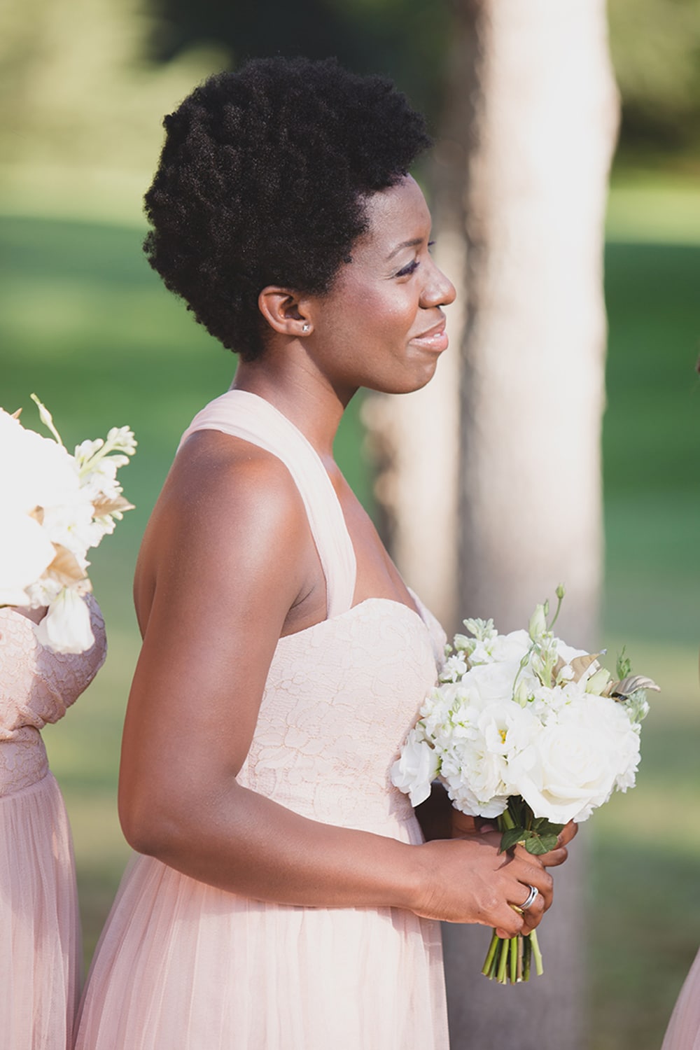 A documentary portrait of a bridesmaid watching the bride and groom during their wedding ceremony on Martha's Vineyard