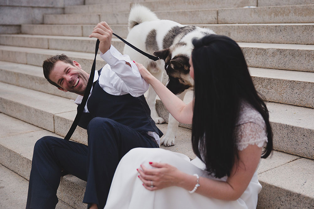 A documentary photograph of couple laughing on the steps of the Boston Common during their Boston Engagement Session