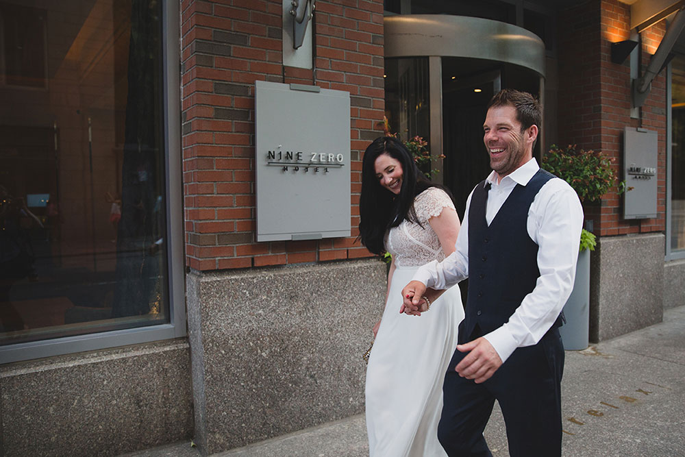 A documentary photograph of couple walking by Nine Zero Hotel during Boston Engagement Session