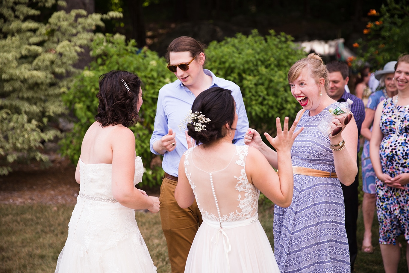 A documentary photograph of two brides celebrating with guests during their Friendly Crossways Wedding