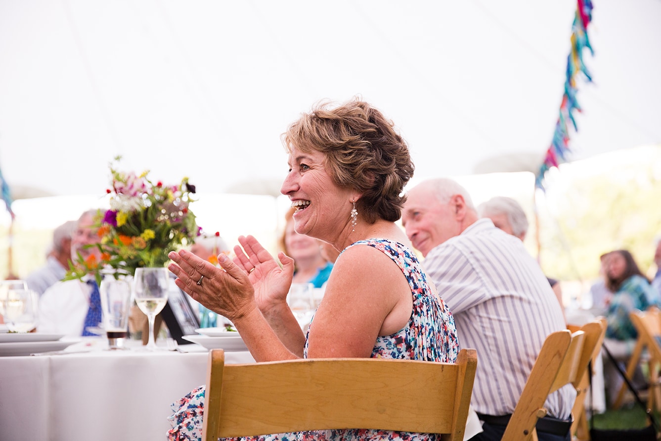 A documentary photograph of a mother clapping during the first dance at a Friendly Crossways Wedding