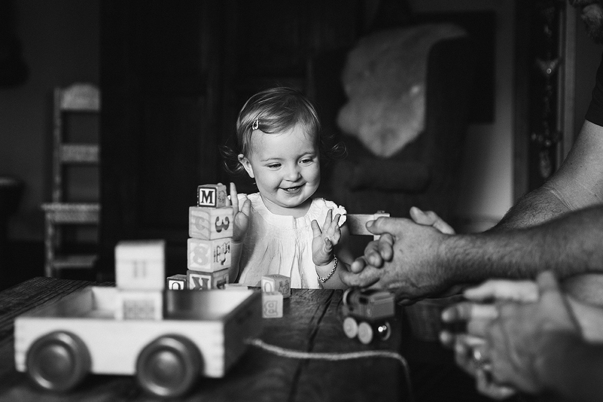 A documentary photograph of a toddler stacking blocks at home during an Evergreen Family Session in Colorado