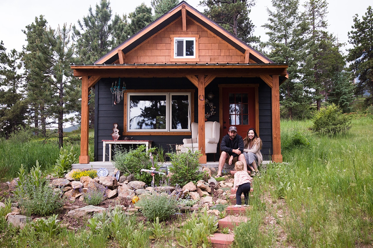 A documentary photograph of a family sitting on the porch of their house during a evergreen family session at home in Colorado