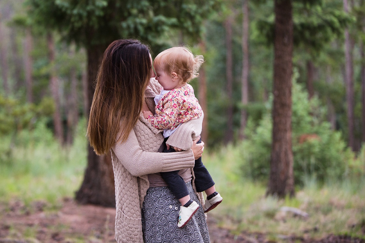 A documentary photograph of mom holding her daughter during their evergreen family session in Colorado