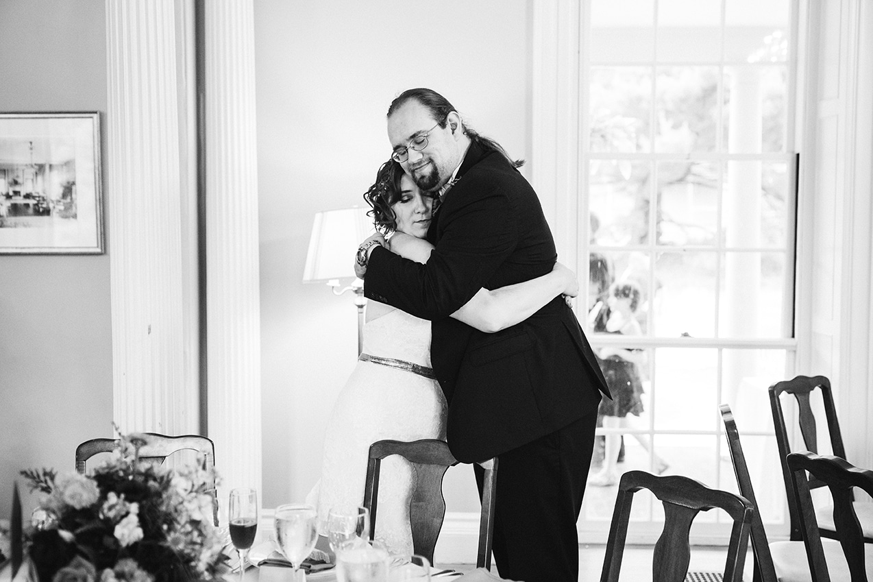 A documentary photograph of a bride hugging her brother during a Lyman Estate Wedding in Boston, Massachusetts