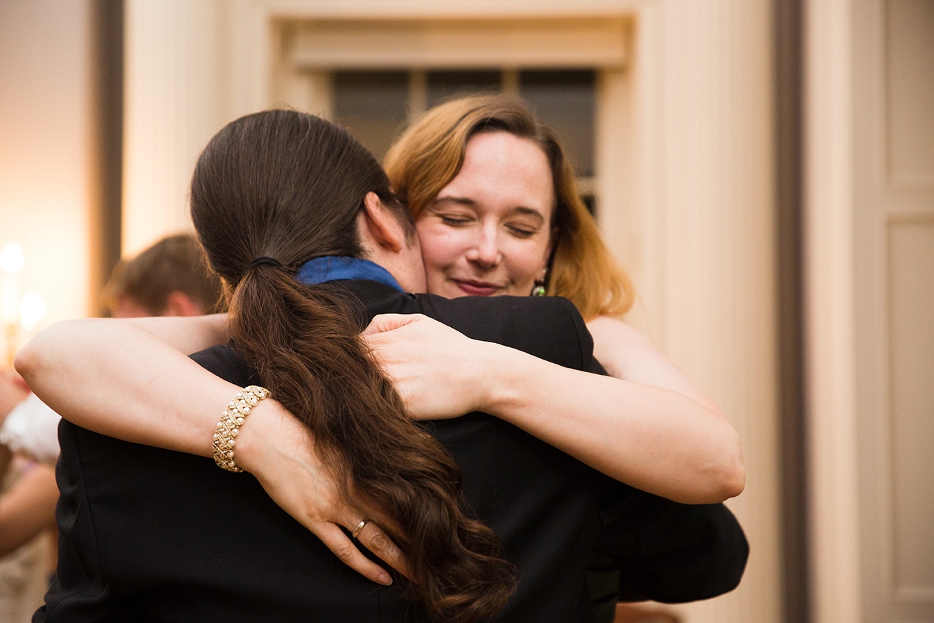 A documentary photograph of guests hugging during a Lyman Estate Wedding in Boston, Massachusetts