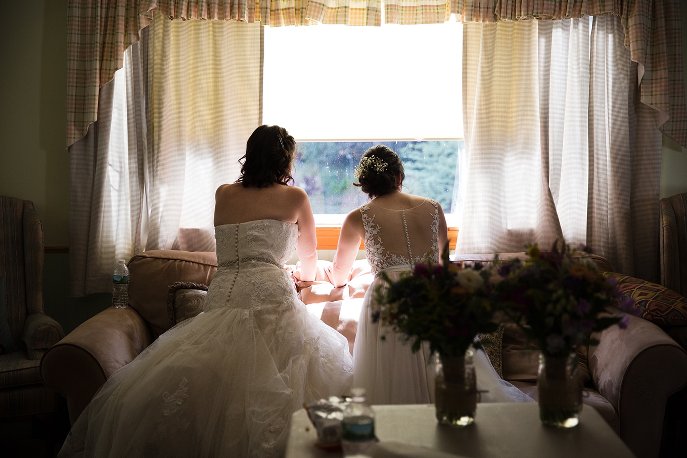 This documentary photograph of two brides watching their guests arrive is one of the best wedding photographs of 2016