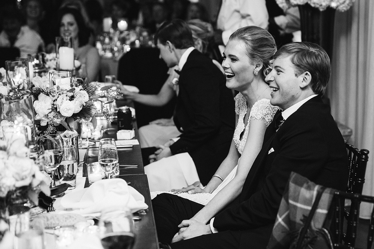 This documentary photograph of a bride and groom laughing during the wedding toasts is one of the best wedding photographs of 2016