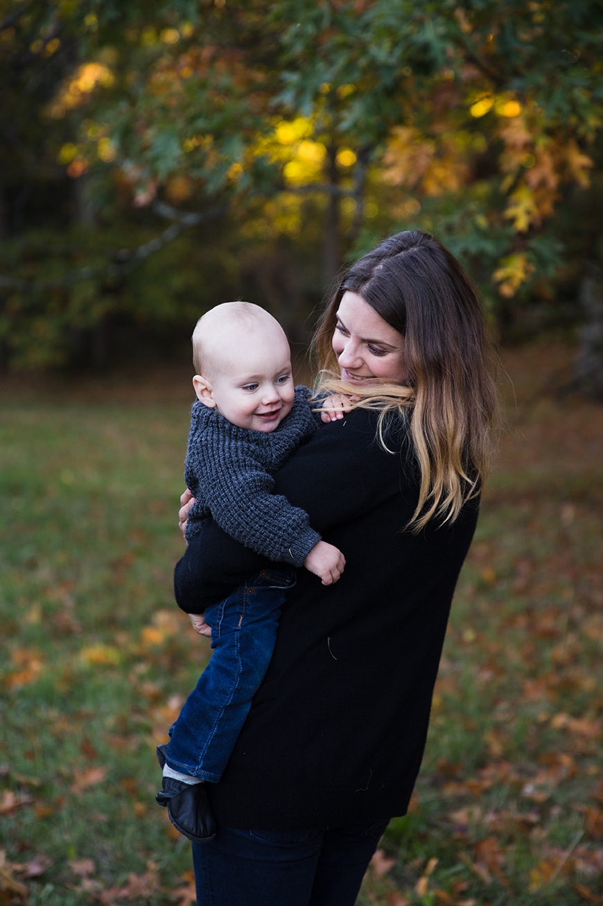 A documentary photograph of a mother holding her baby boy during a lifestyle family session at the Arnold Arboretum in Boston, Massachusetts
