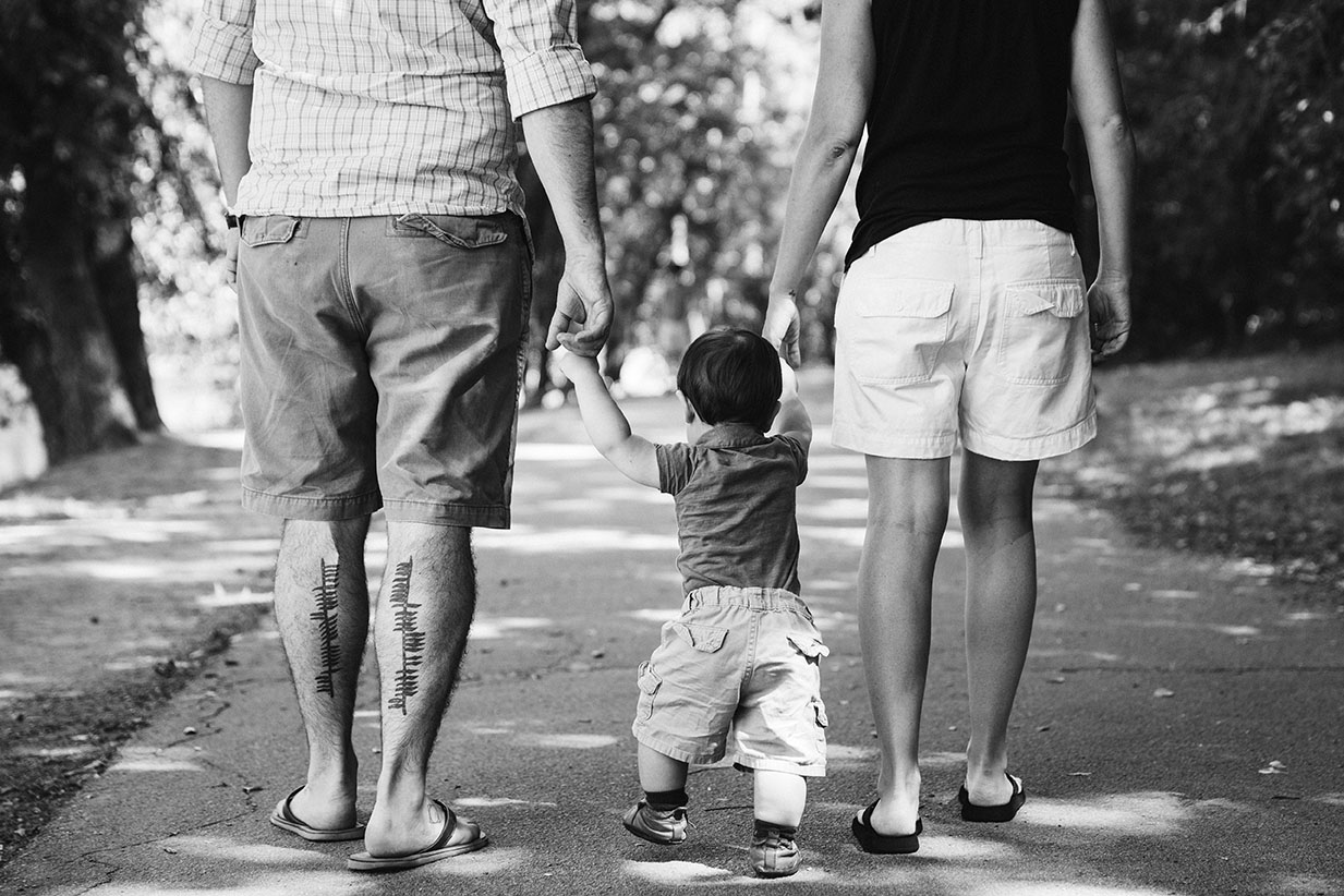 A lifestyle portrait of a family walking through Jamaica Pond during a Boston Family Session