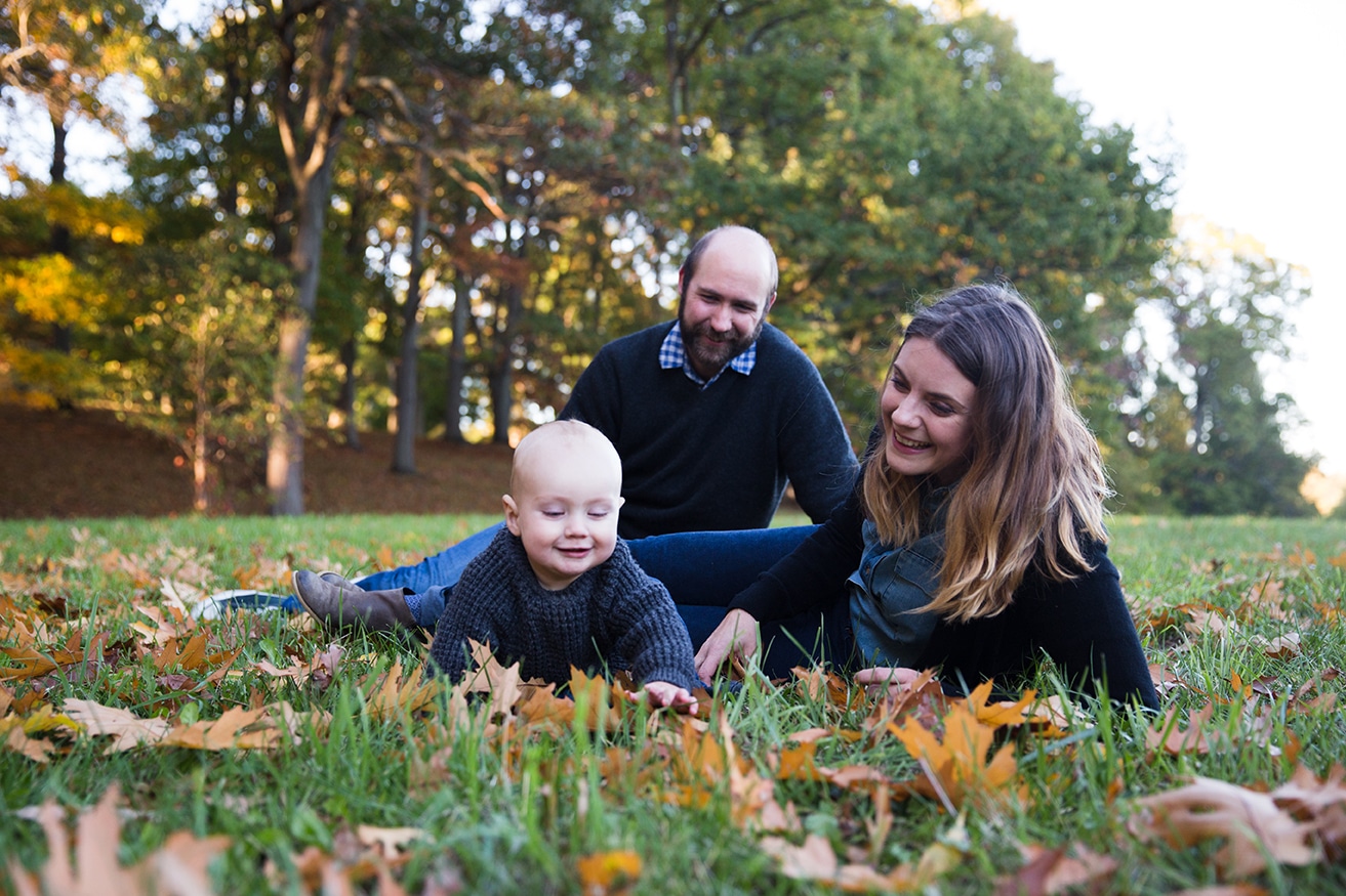 A documentary photograph of a family playing in the grass during a lifestyle family session in the Arnold Arboretum