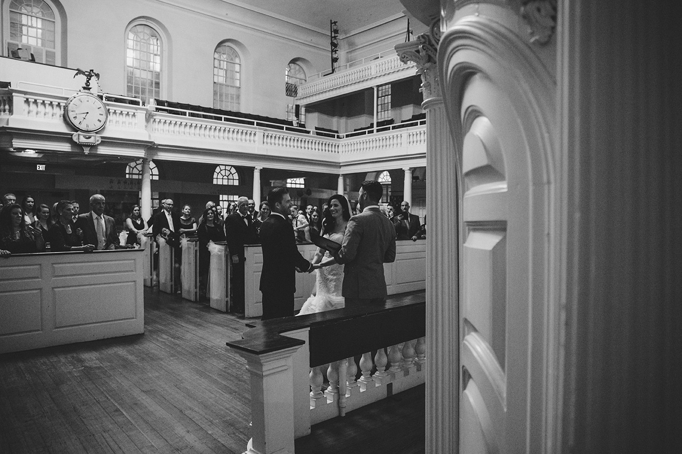 A documentary photograph of a bride and groom saying their vows during their old south meeting house and marliave wedding in Boston, Massachusetts