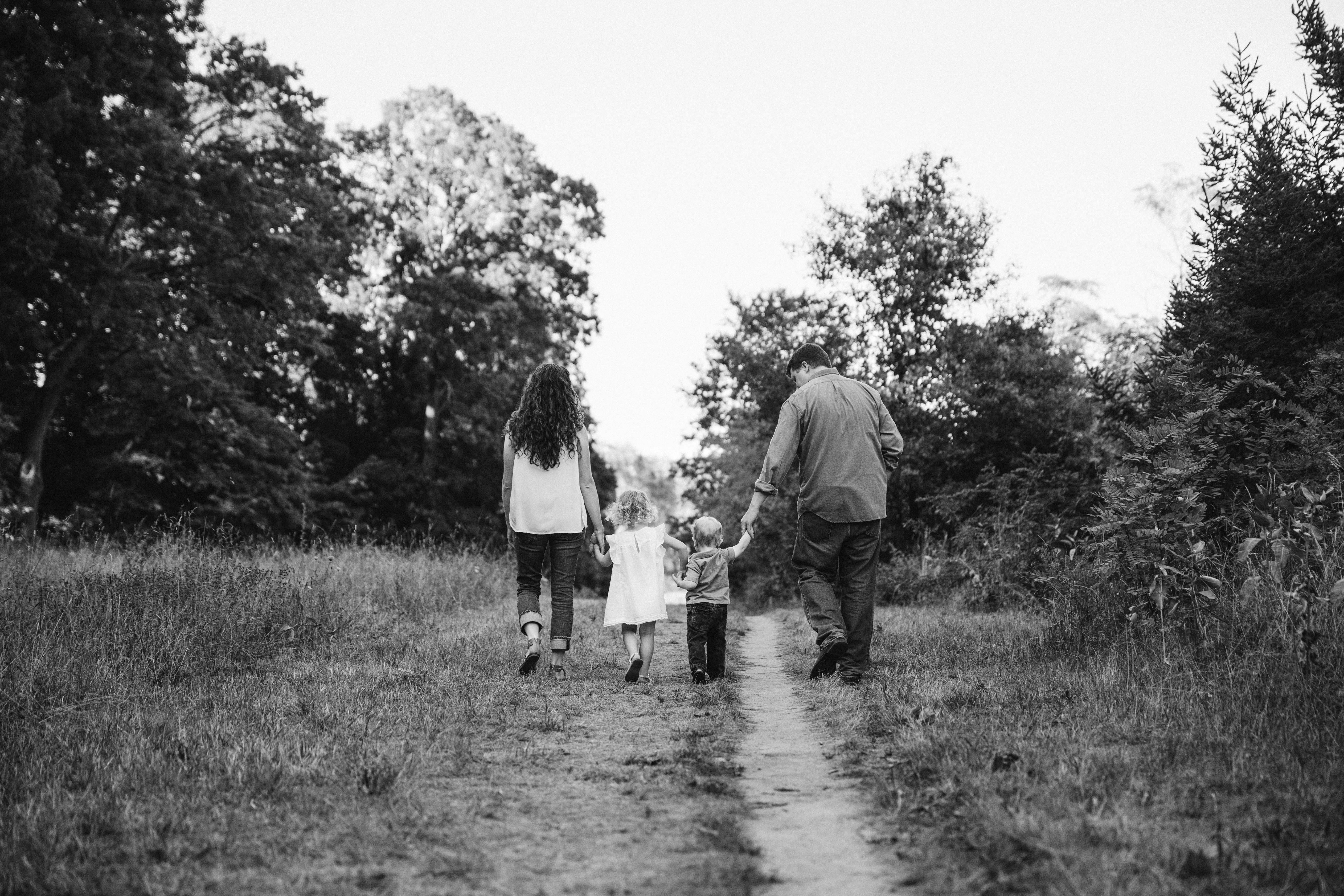 A documentary photograph of a family walking together during their Arnold Arboretum Family Session in Boston, Massachusetts