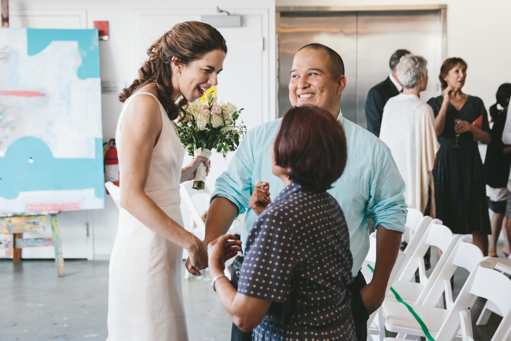 A documentary photograph of a bride talking with guests at her Artists for Humanity Wedding in Boston
