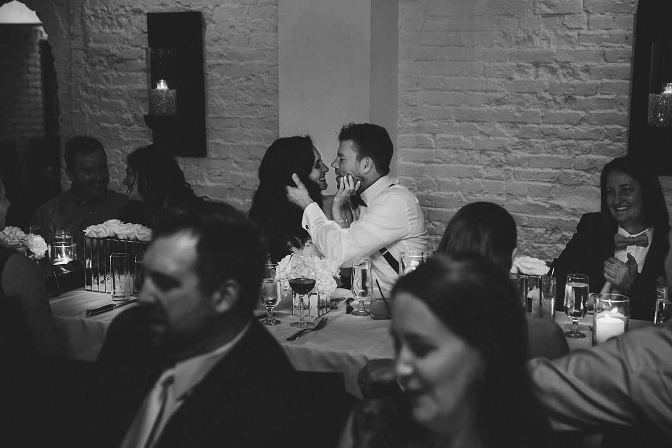 A documentary photograph of a bride and groom kissing during their marliave wedding reception in Boston, Massachusetts