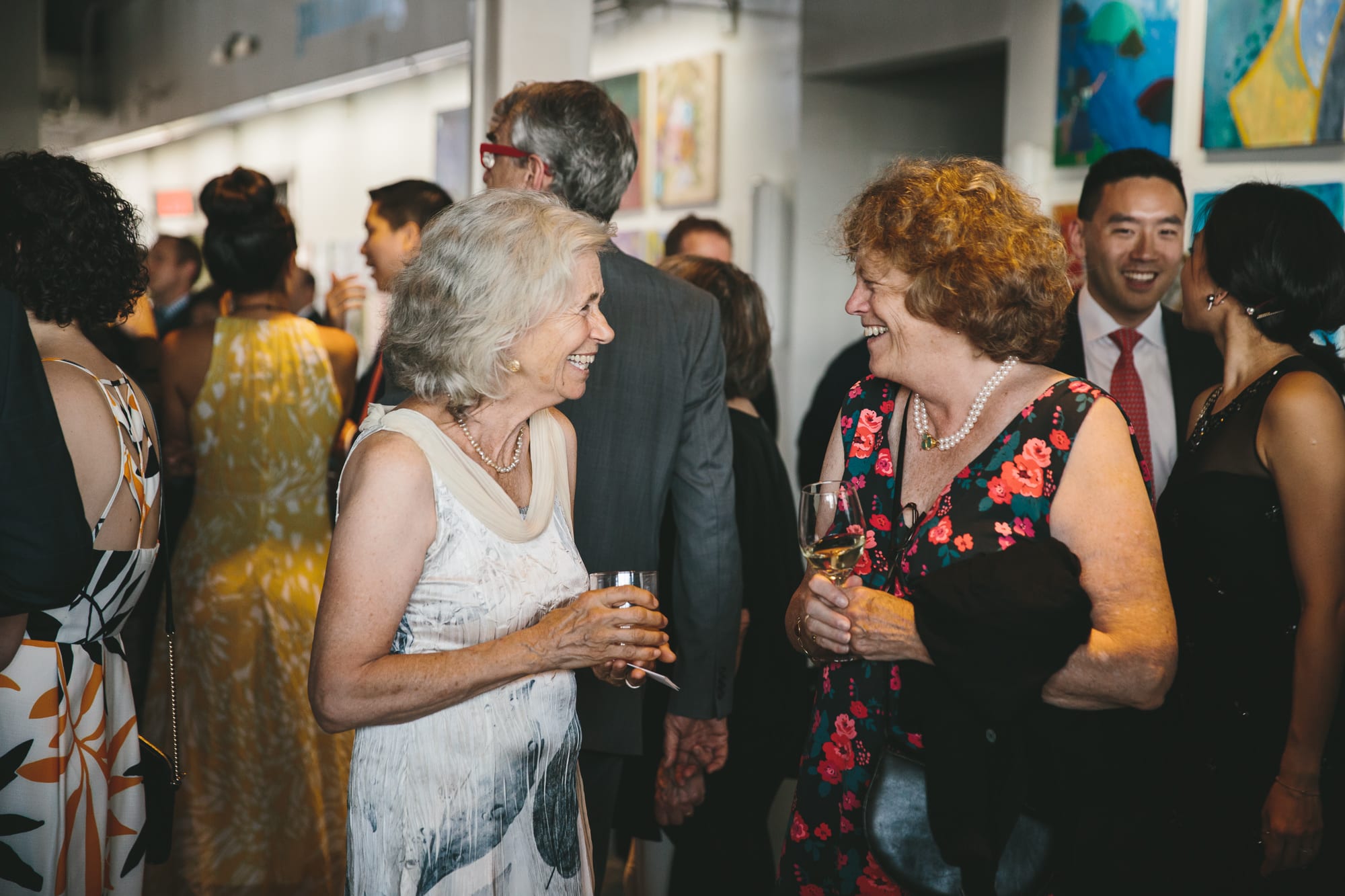 A documentary photograph of guests talking during an artists for humanity wedding in Boston