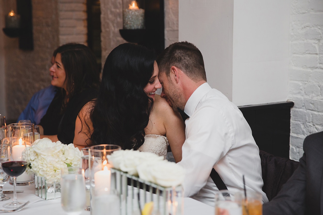 A documentary photograph of a bride and groom sharing an intimate moment during their wedding reception at Marliave in Boston, Massachusetts