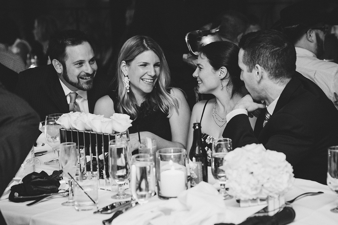 A documentary photograph of guests talking and laughing during a Marliave Wedding reception in Boston, Massachusetts