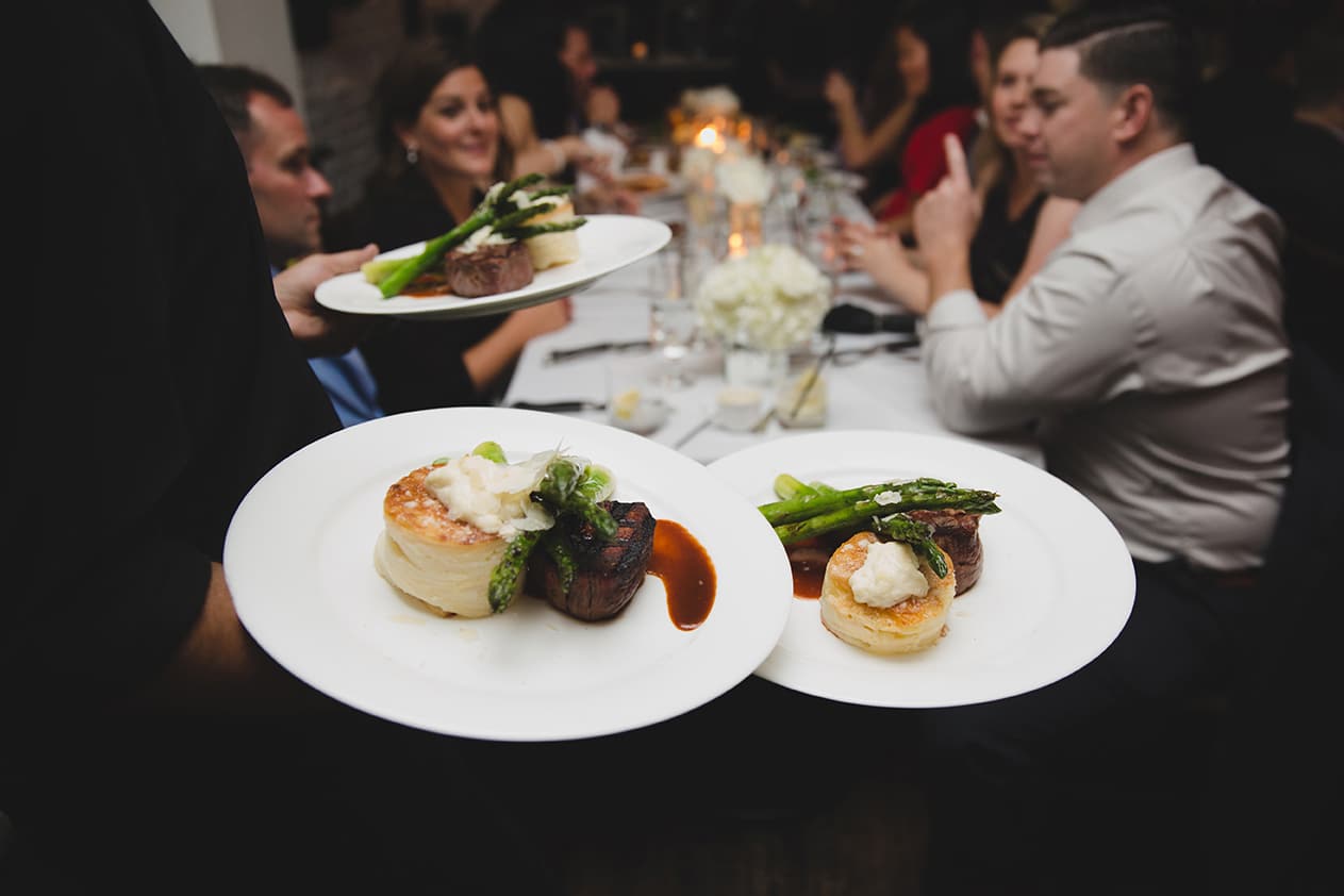 A documentary photograph of dinner being served at a Marliave wedding reception in Boston, Massachusetts