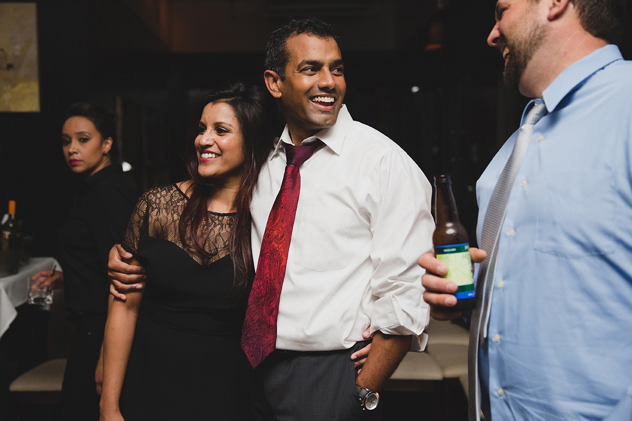 A documentary photograph of guests talking and laughing during a Marliave wedding reception in Boston, Massachusetts
