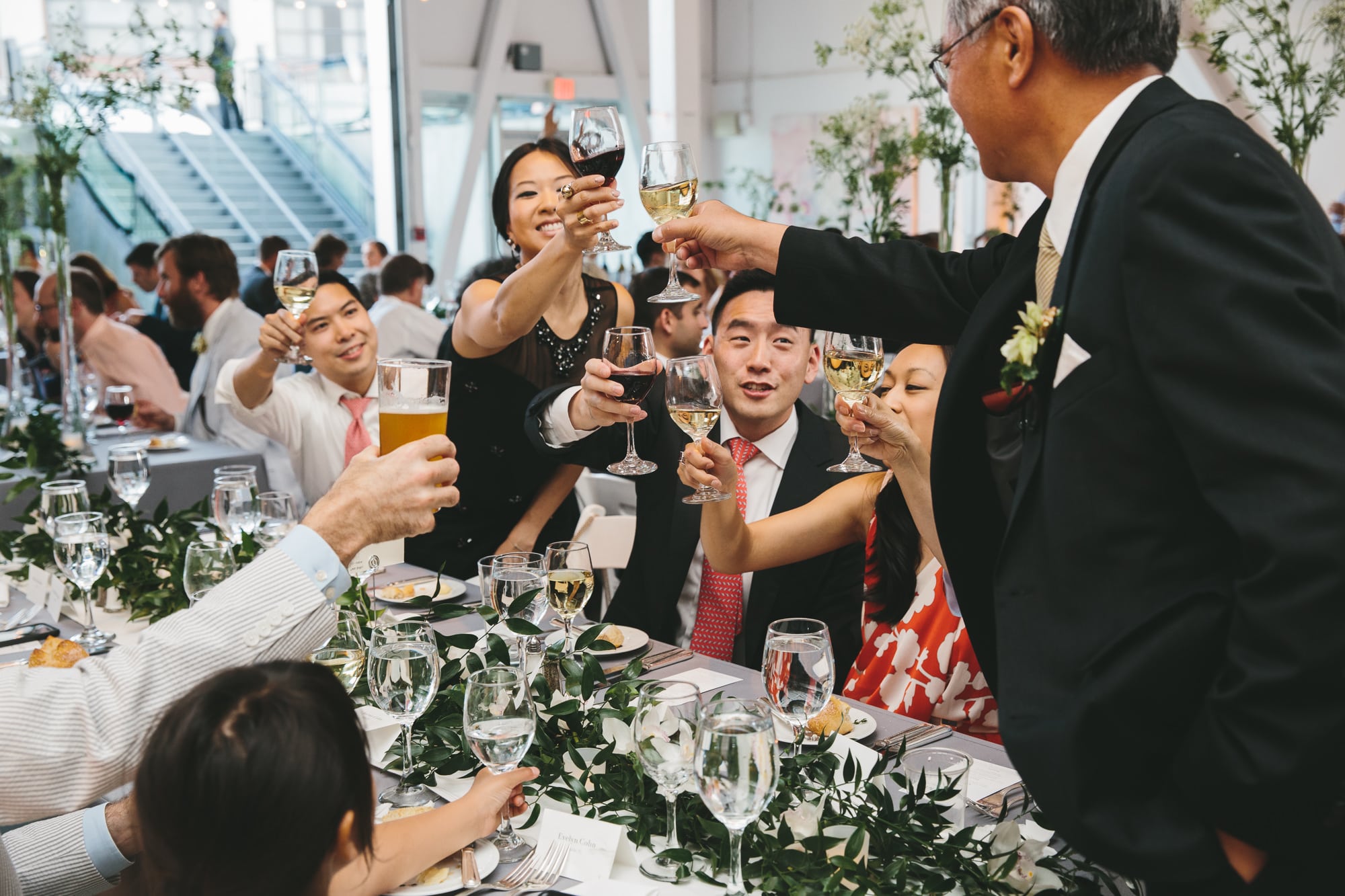 A documentary photograph of guests toasting the couple during an Artists for Humanity Wedding in Boston