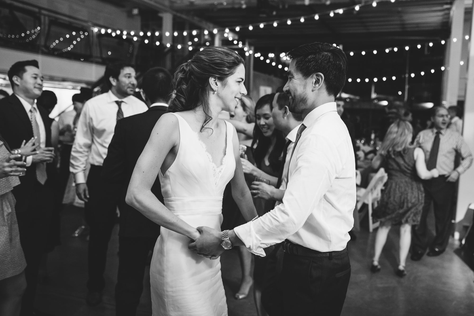 A documentary photograph of a bride and groom dancing at their Artists for Humanity Wedding in Boston