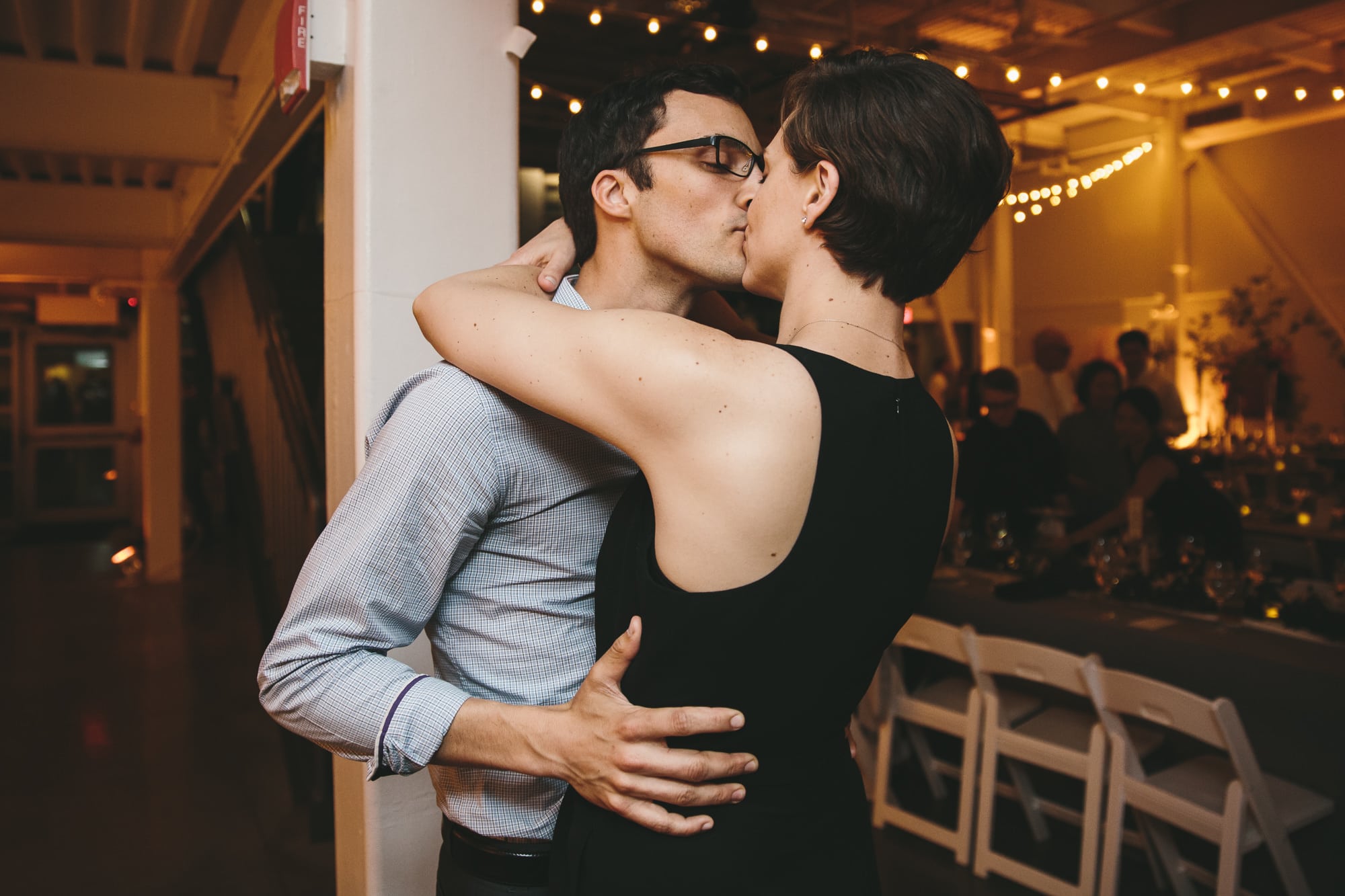 A documentary photograph of guests kissing during an Artist for Humanity Wedding in Boston