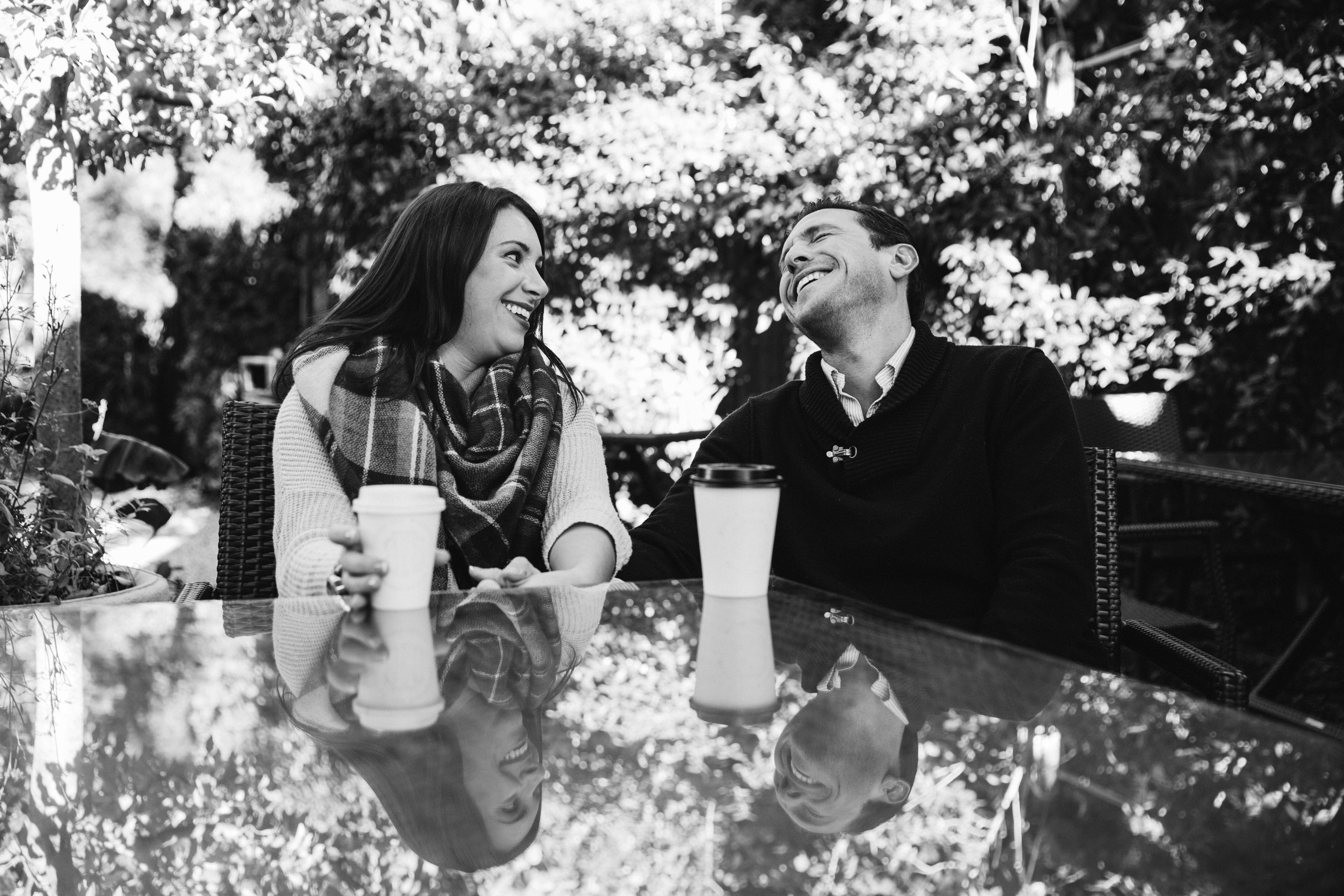 A documentary photograph of a couple laughing while having a coffee together at their honeymoon photo session in Martha's Vineyard
