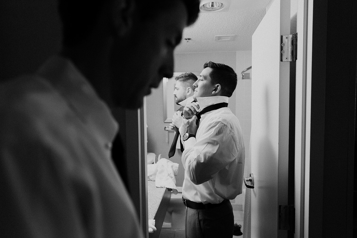 A documentary photograph of groomsmen getting ready for a moraine farm wedding in Beverly, Massachusetts