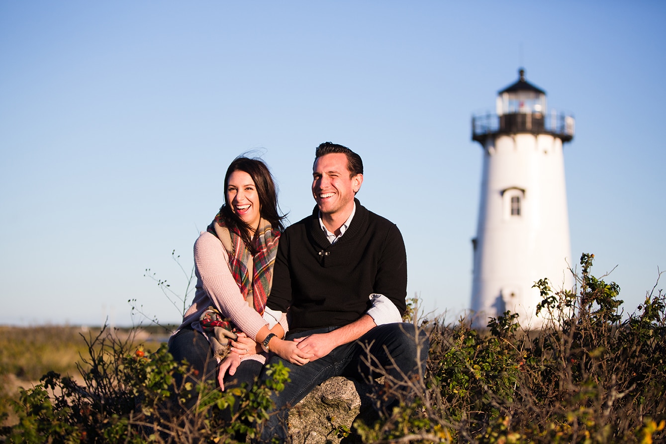 A documentary photograph of a couple laughing near the lighthouse during their honeymoon photo session on Martha's Vineyard