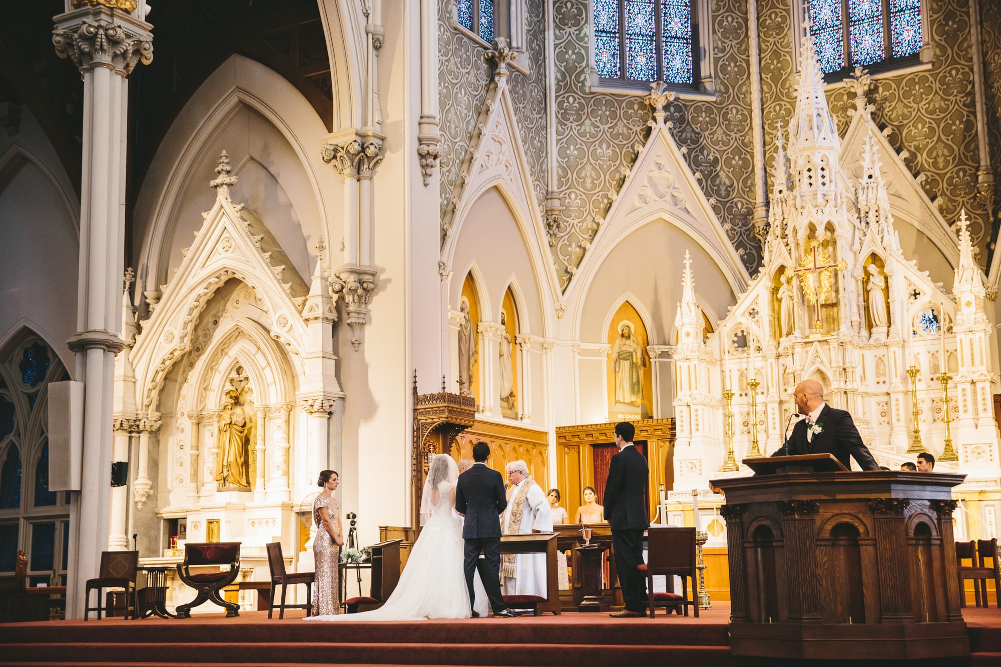 A documentary photograph of couple being married at the Cathedral of the Holy Cross before their State Room Wedding Reception in Boston, Massachusetts