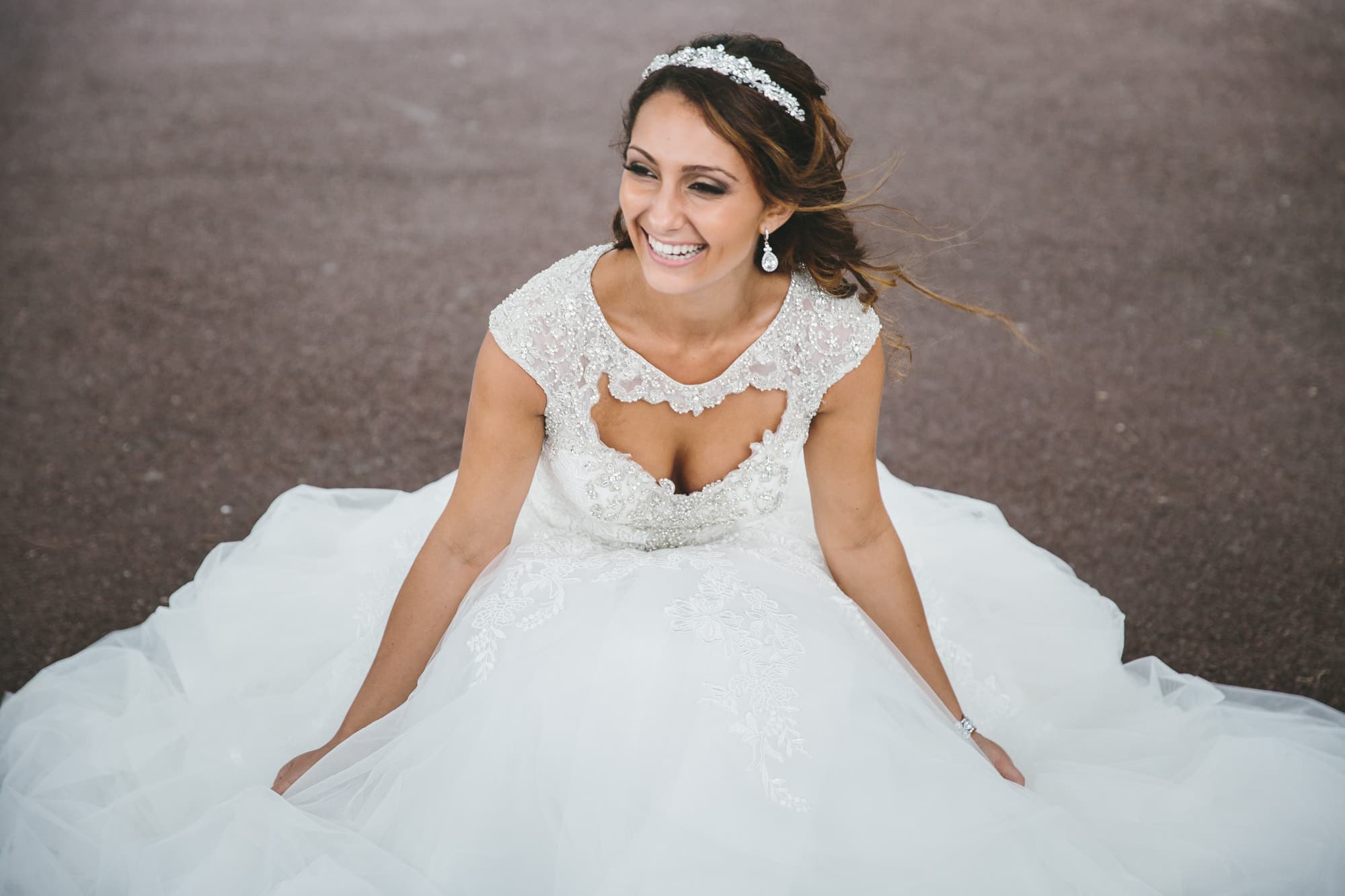 A documentary portrait of a bride laughing at Christopher Columbus Park during her State Room Wedding