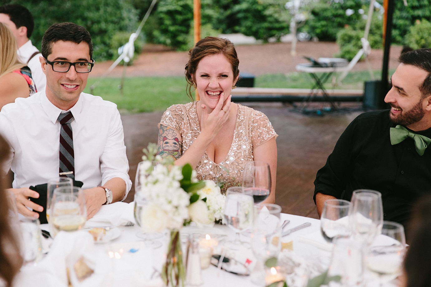 A documentary photograph of guests laughing during the reception of a Moraine Farm Wedding in Beverly, Massachusetts