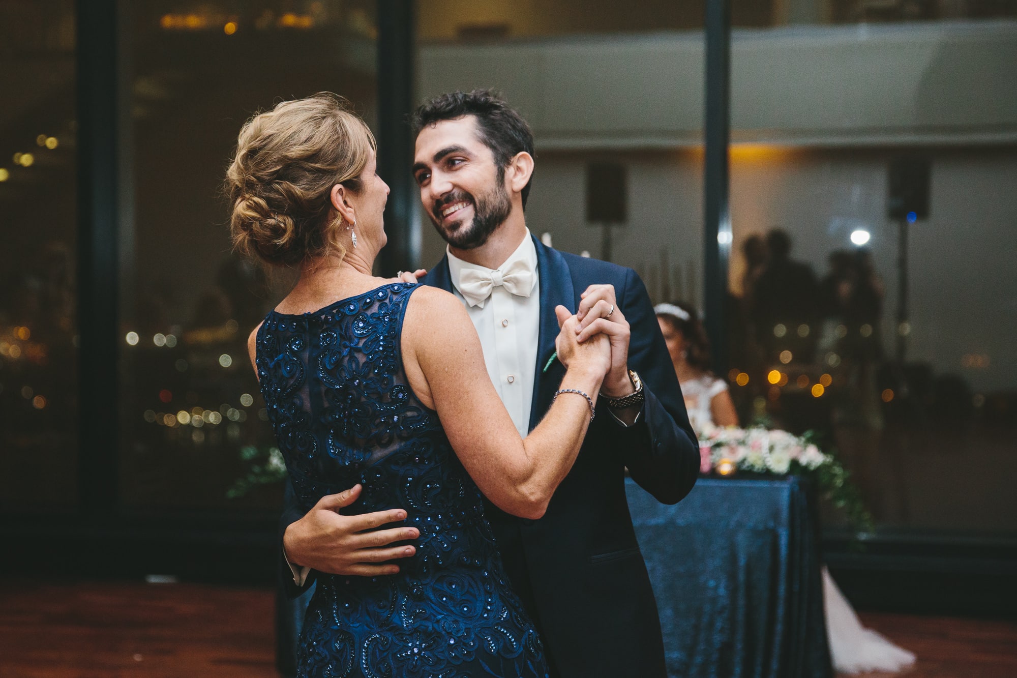 A documentary photograph of a groom dancing with his mother during a State Room Wedding in Boston, Massachusetts