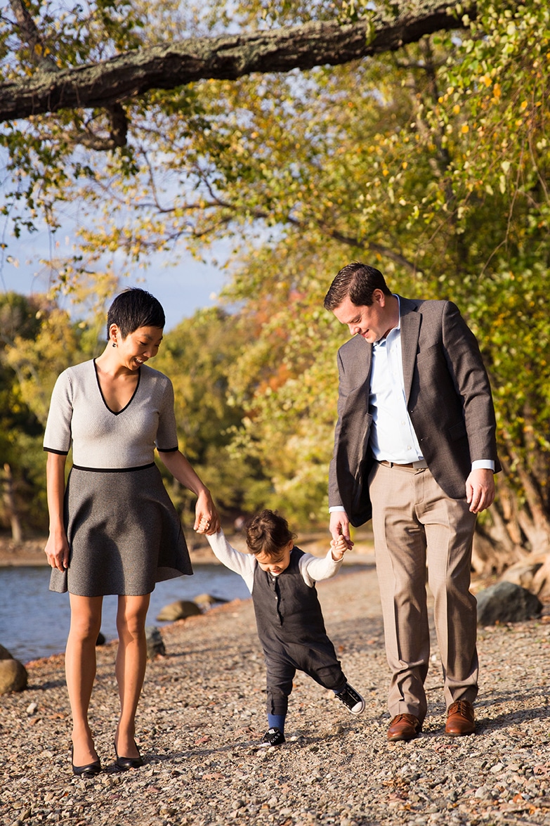 A documentary photograph of a family walking together at Jamaica Pond during their family session