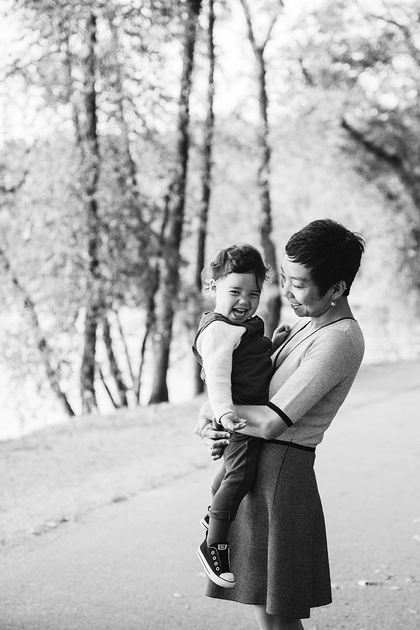 A documentary photograph of mom holding her toddler during a Jamaica Pond family photo session in Boston
