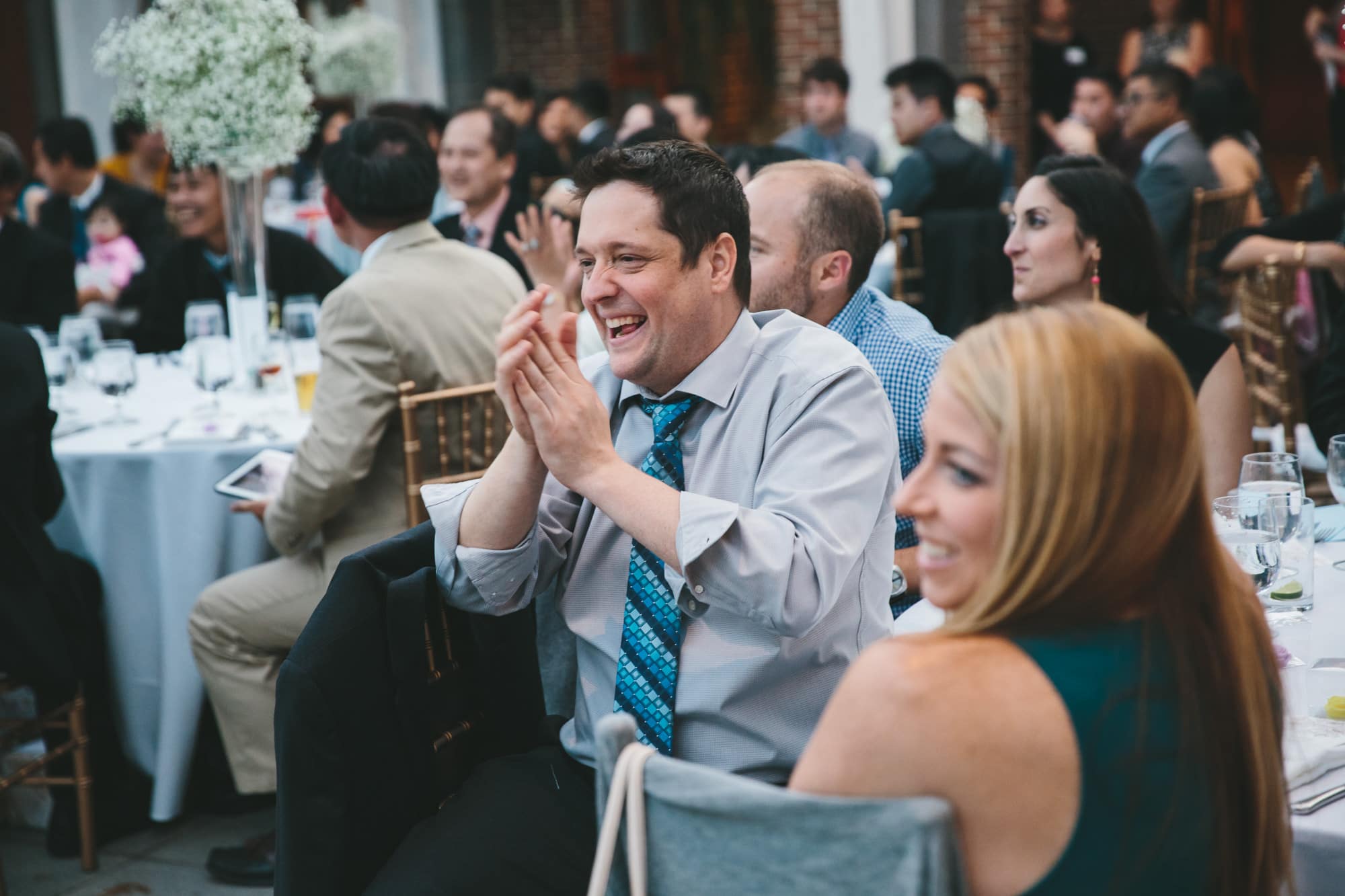 A documentary photograph of guests clapping during the speeches at a Tower Hill Wedding in Boylston, Massachusetts
