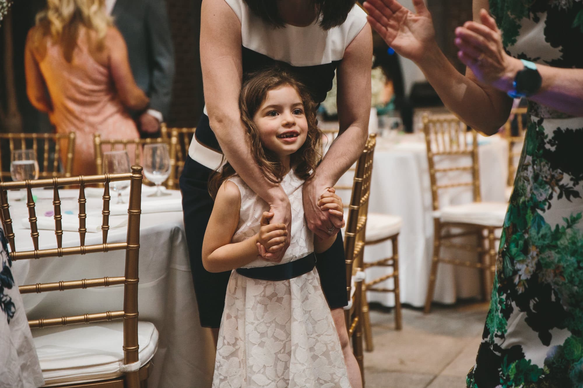 A documentary photograph of a little girl watching guests dance at at Tower Hill Wedding reception in Boylston, Massachusetts