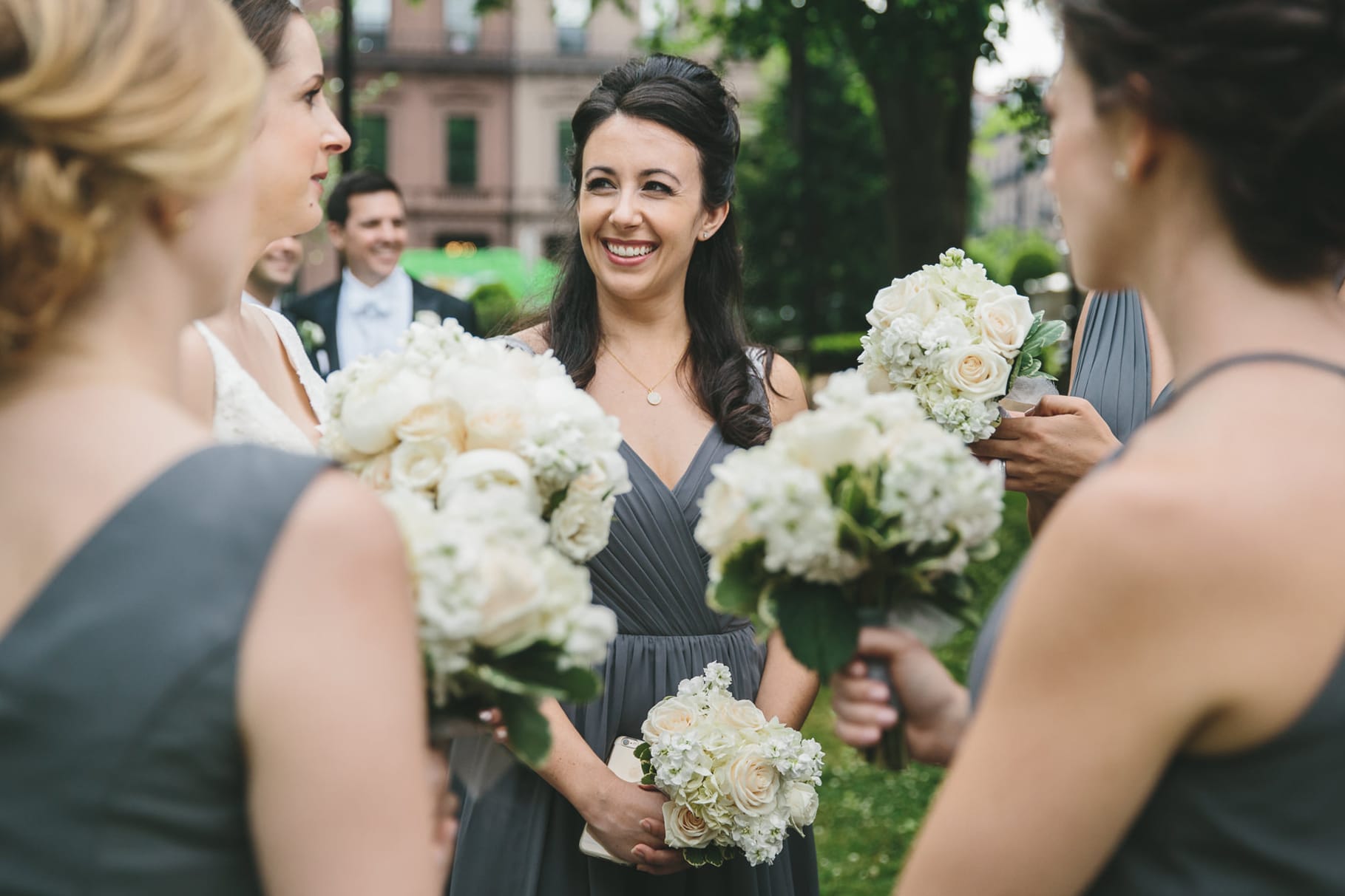 A documentary photograph of bridesmaids talking at the Boston Public Gardens before a State Room Wedding