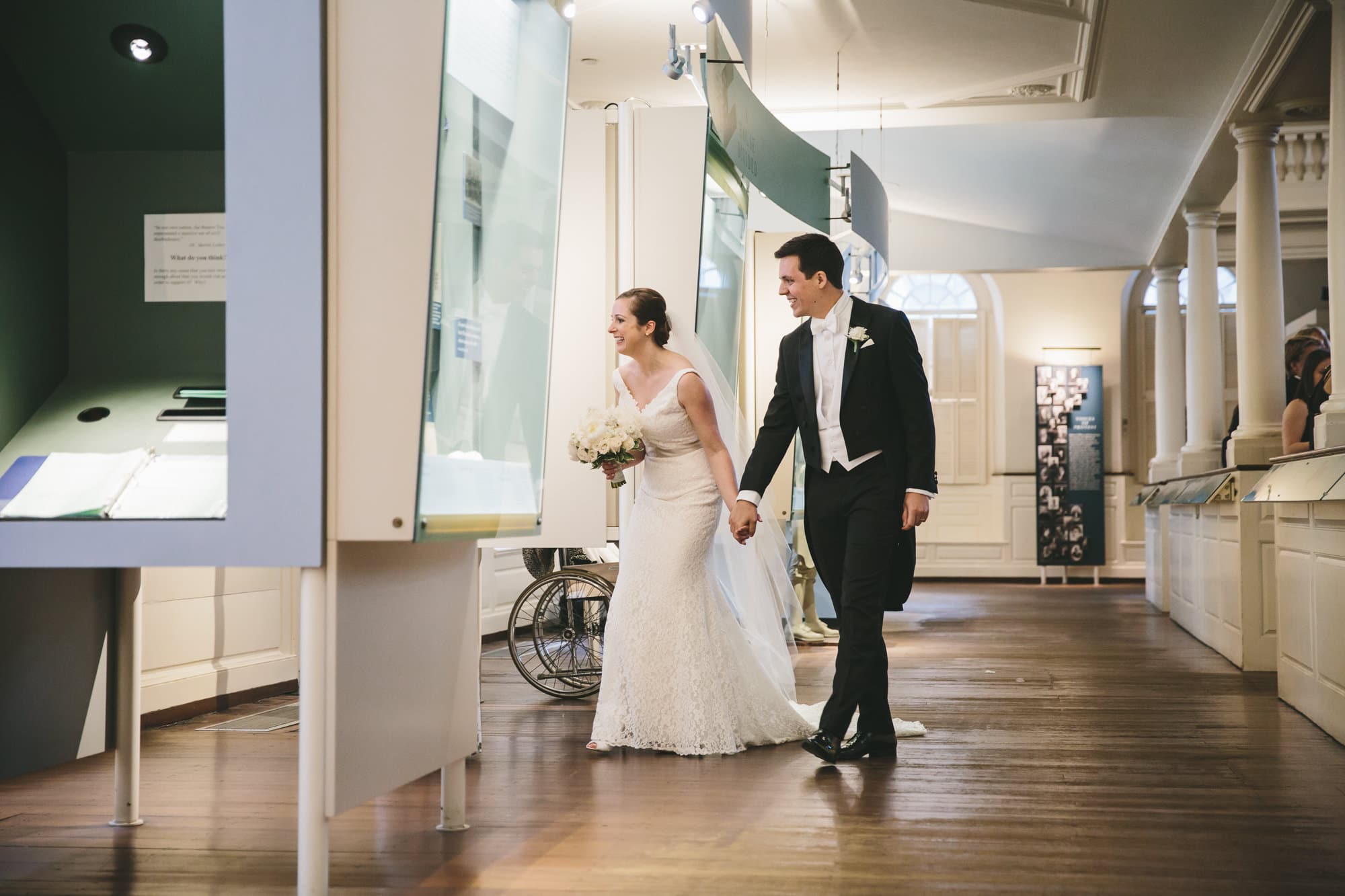 A documentary photograph of a bride and groom walking through the old south meeting house after their wedding ceremony 
