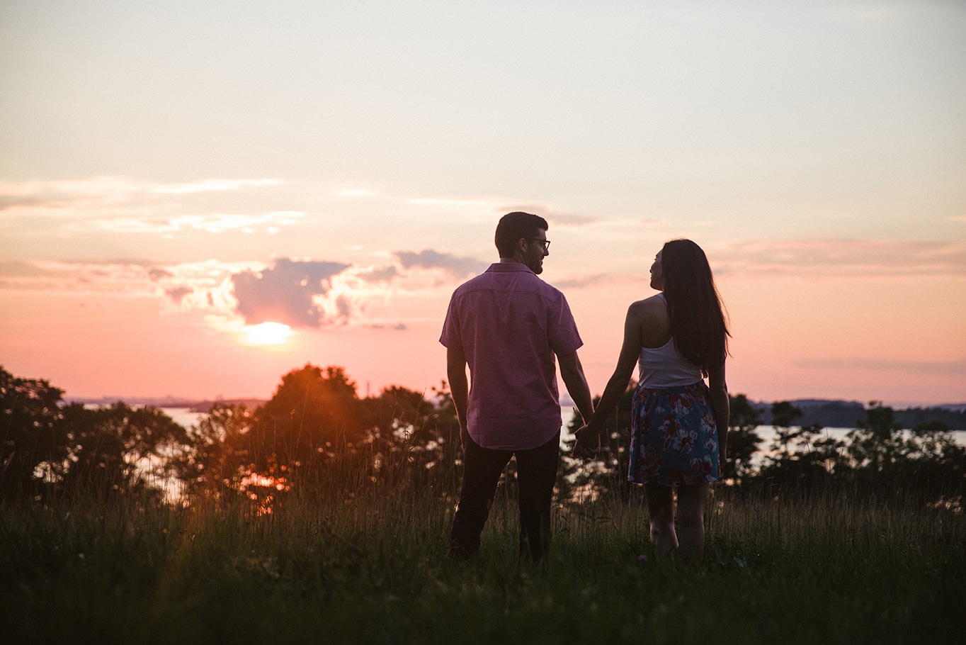 A documentary portrait of a couple looking out at the sunset during their World's End Engagement Session in Boston, Massachusetts