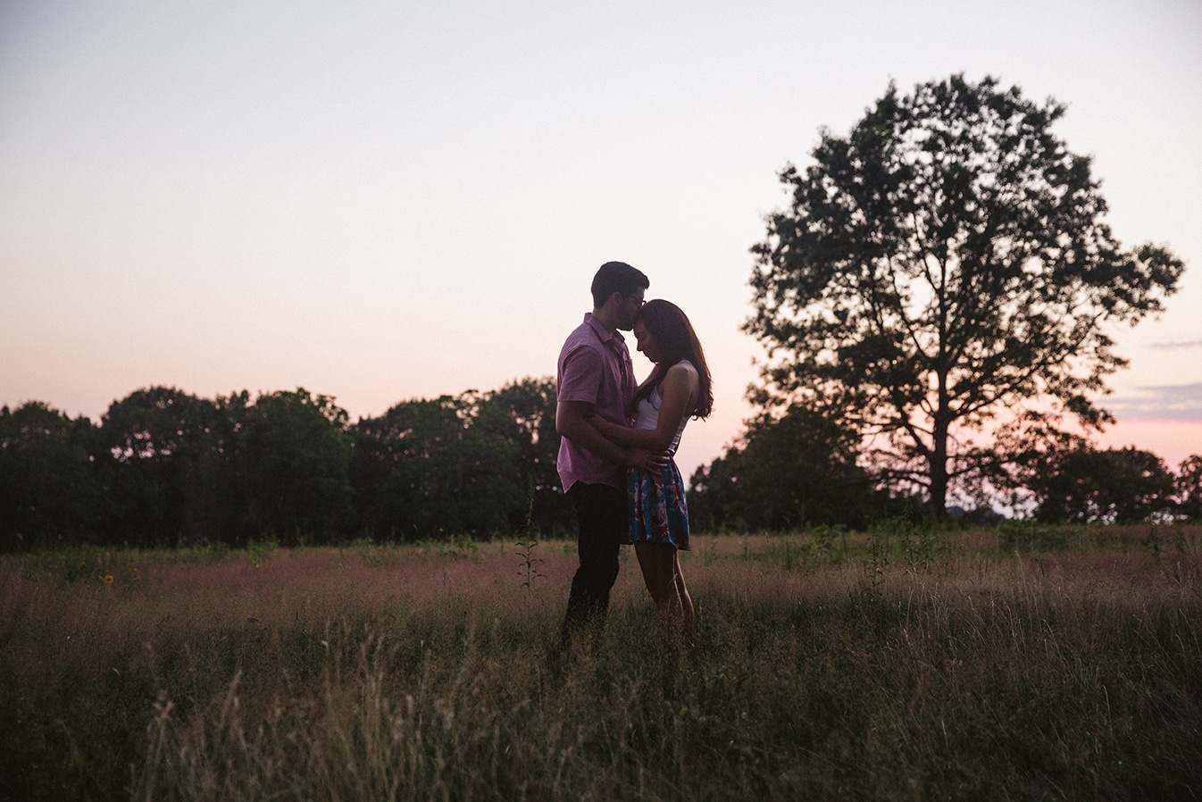 A couple kiss during their documentary engagement session at the World's End in Hingham, Massachusetts
