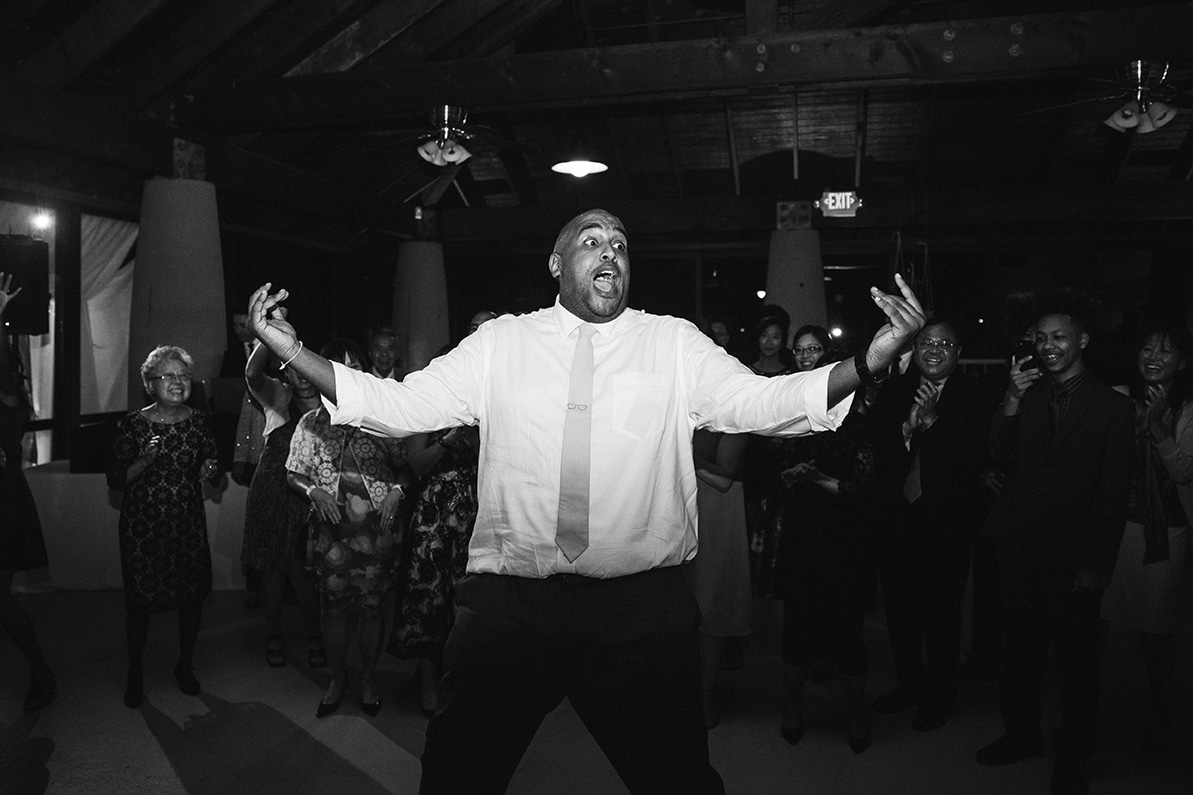 A documentary photograph a of groomsman dancing at a plimoth plantation wedding in plymouth, massachusetts