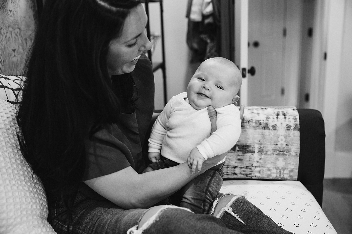 A documentary photograph of a mom holding her baby boy during an in home family lifestyle session in Boston, Massachusetts