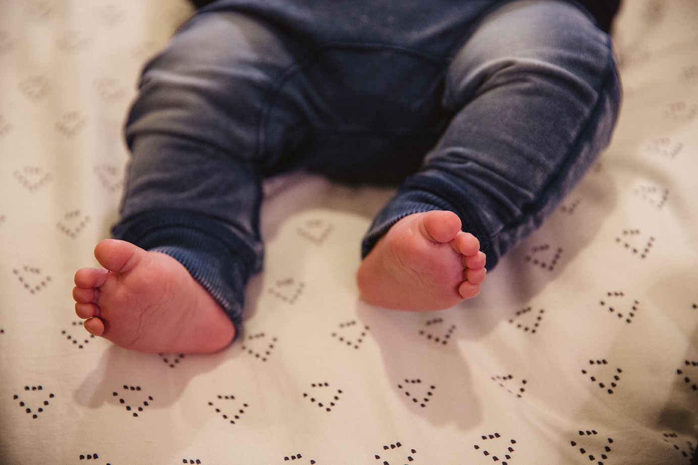A documentary photograph of a babies feet during an in home family lifestyle session in Boston, Massachusetts
