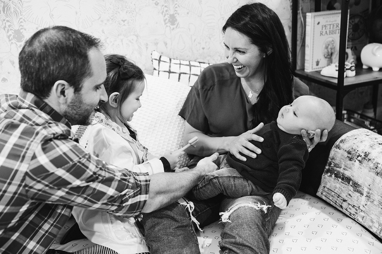 A documentary photograph of a family playing together during their in home family lifestyle session in Boston, Massachusetts