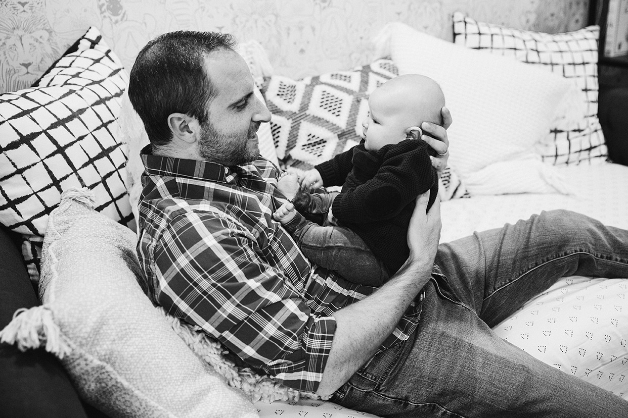 A documentary photograph of a dad holding his baby boy during an in home family lifestyle session in Boston, Massachusetts
