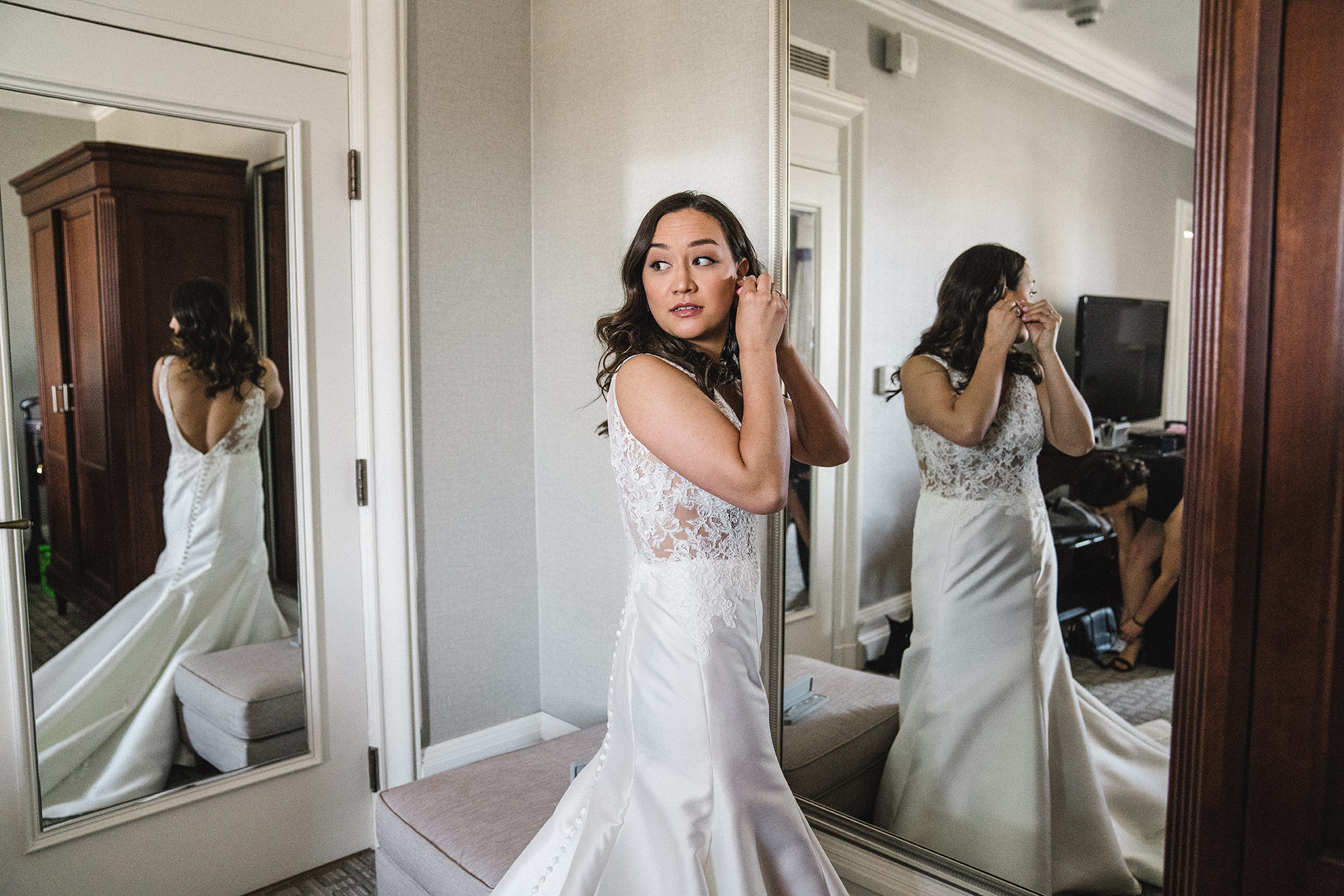 A documentary photograph of a bride putting in her earring before her Fairmont Copley Wedding in Boston